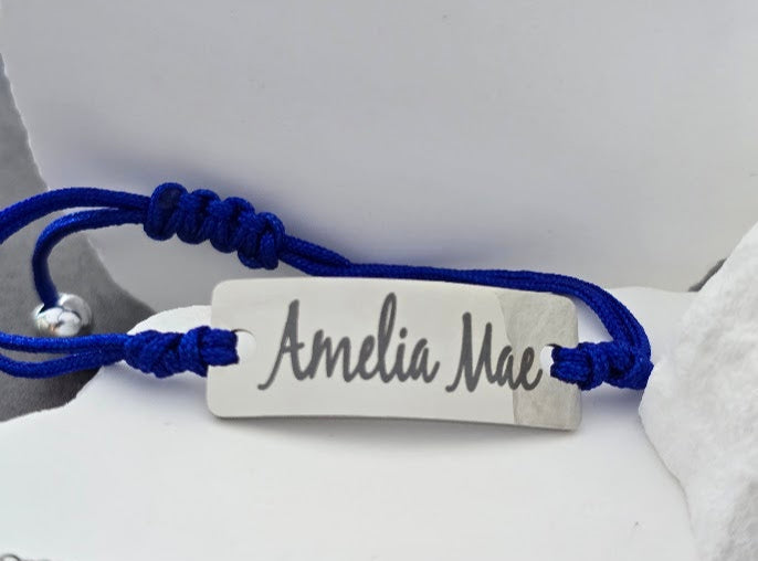 Bracelet with 'Amelia Mae' engraving on a white stone surface